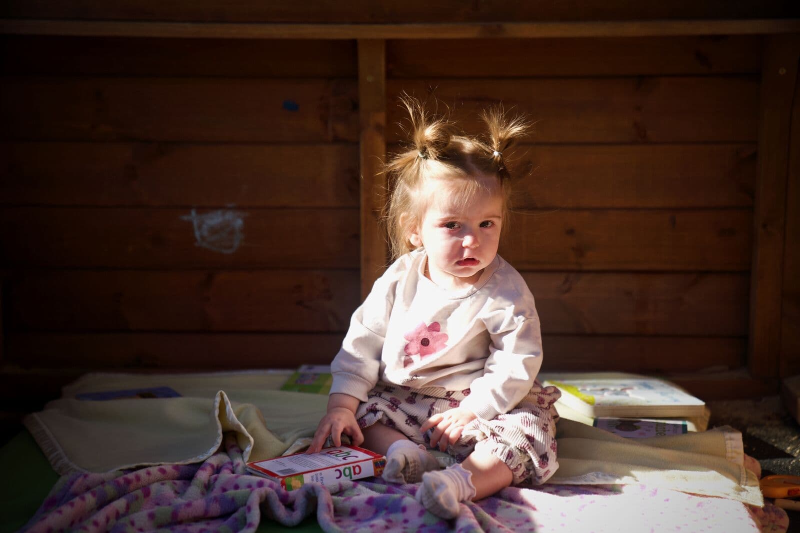 A child settled into the reading cubby with a picture book at Guthrie